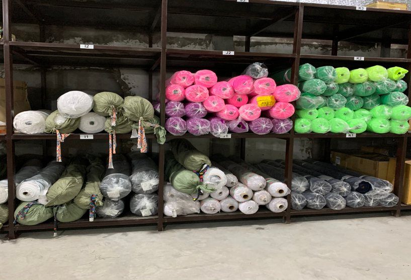 Fabric rolls stored on racks in the TAV Factory 1 warehouse